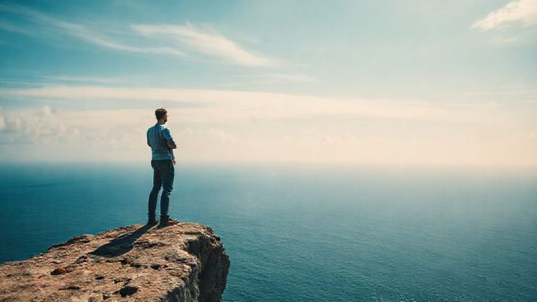 Ilustrasi jebakan Coast FIRE: Seseorang berdiri di tepi tebing memandang lautan luas, simbol kebebasan finansial, namun ada awan gelap di kejauhan yang merepresentasikan risiko tersembunyi.